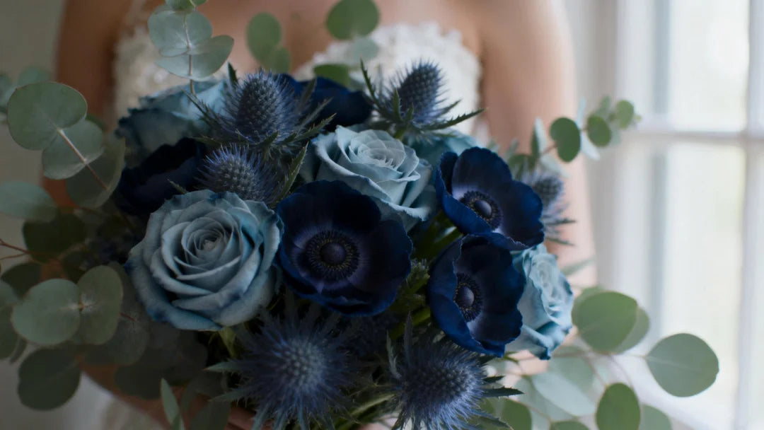 Cinematic close-up photography of a bridal bouquet featuring Dusty Blue roses, deep Navy Blue anemones, and Slate Blue thistle