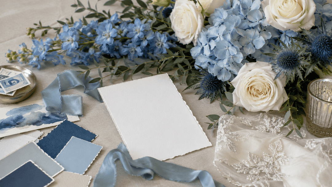 Editorial blue wedding florals with delphinium, powder blue hydrangeas, steel-blue thistle, white roses, and greenery.