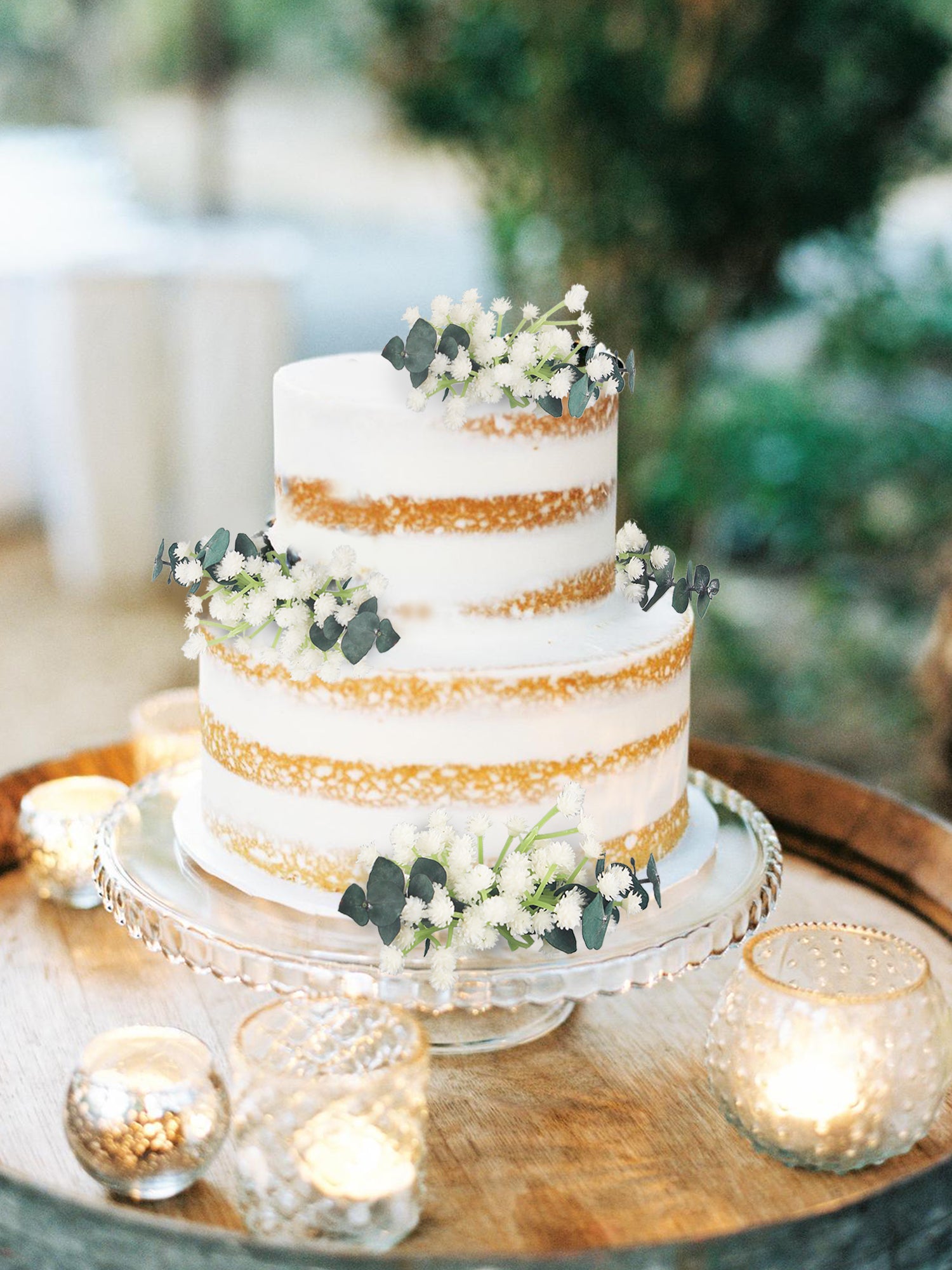 wedding cake table floral arrangement base with baby's breath, greenery wrapped around cake stand boho